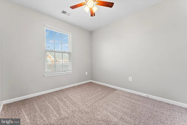 an empty room with a chandelier fan