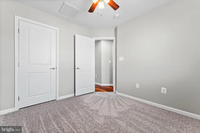 an empty room with closet and fan