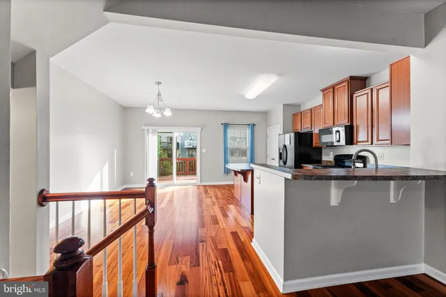 a large kitchen with stainless steel appliances granite countertop a refrigerator a sink dishwasher a stove and white countertops with wooden floor