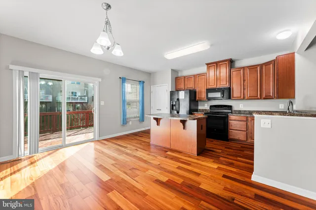 a kitchen with stainless steel appliances granite countertop a refrigerator stove top oven and cabinets