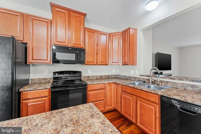 a kitchen with stainless steel appliances granite countertop a stove sink microwave and refrigerator