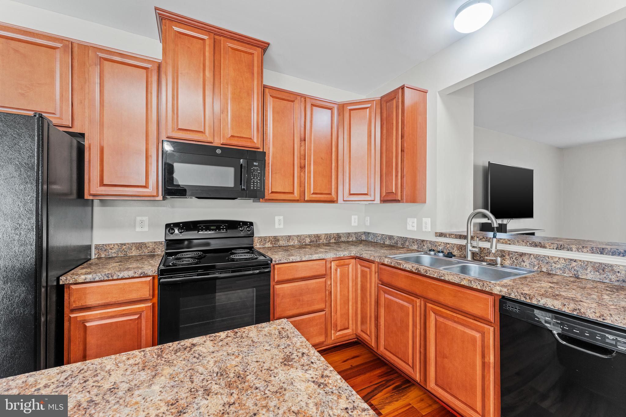 104 Spring Park Lane, Unit 43 Fredericksburg, VA 22405 - Photo 7 of 36 a kitchen with stainless steel appliances granite countertop a stove sink microwave and refrigerator