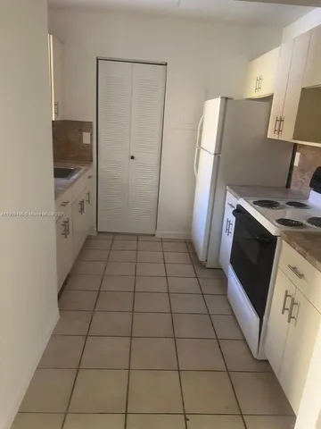 a kitchen with a stove top oven and white cabinets