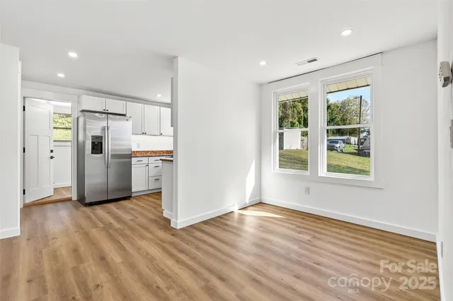 a view of a kitchen with wooden floor and a window