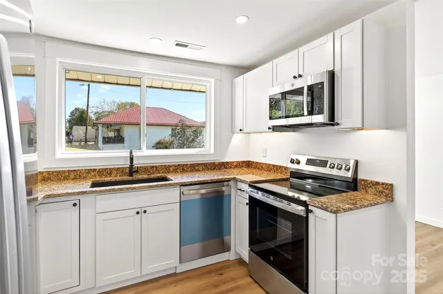 a kitchen with stainless steel appliances granite countertop a stove and a microwave