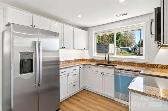 a kitchen with stainless steel appliances granite countertop a refrigerator and a sink