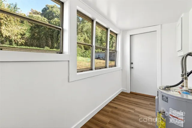 a view of a room with wooden floor and front door