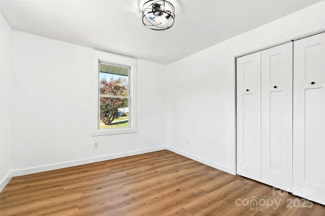 an empty room with wooden floor and a window