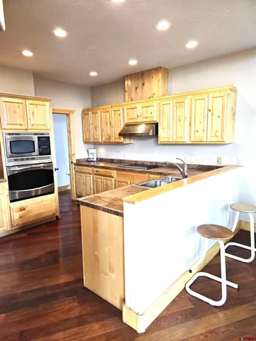 a kitchen with stainless steel appliances granite countertop a stove and a wooden floors