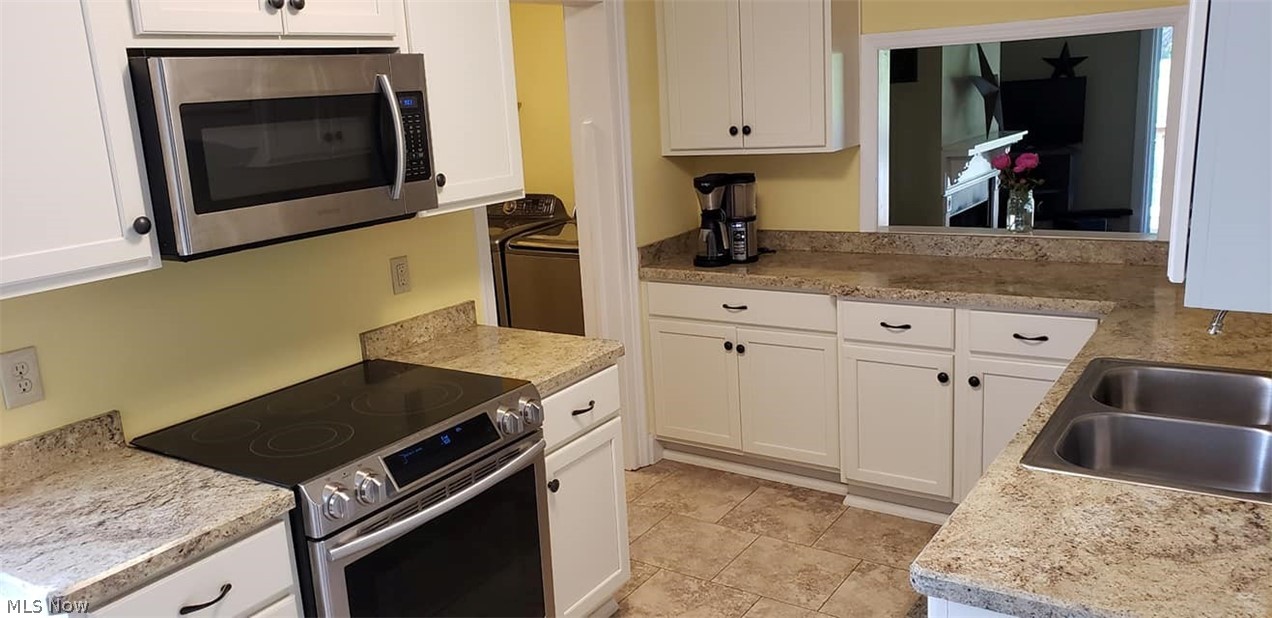 15201 Trask Road Thompson, OH 44086 - Photo 13 of 28 Another view of the kitchen - with space for all your kitchen needs - window thru to the living room, and laundry area at the rear left...handy access for any family