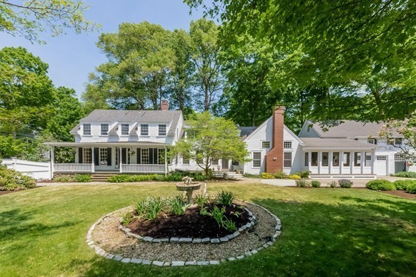 a front view of a house with a garden and plants