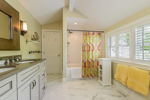 595 Bay Road Hamilton, MA 01982 - Photo 20 of 30 a spacious bathroom with a granite countertop sink a mirror a bathtub and next to a window