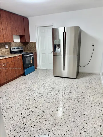 a kitchen with stainless steel appliances granite countertop a refrigerator a stove and a sink