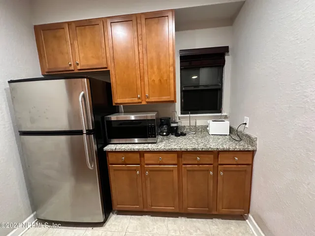 a kitchen with metallic refrigerator freezer and a dishwasher