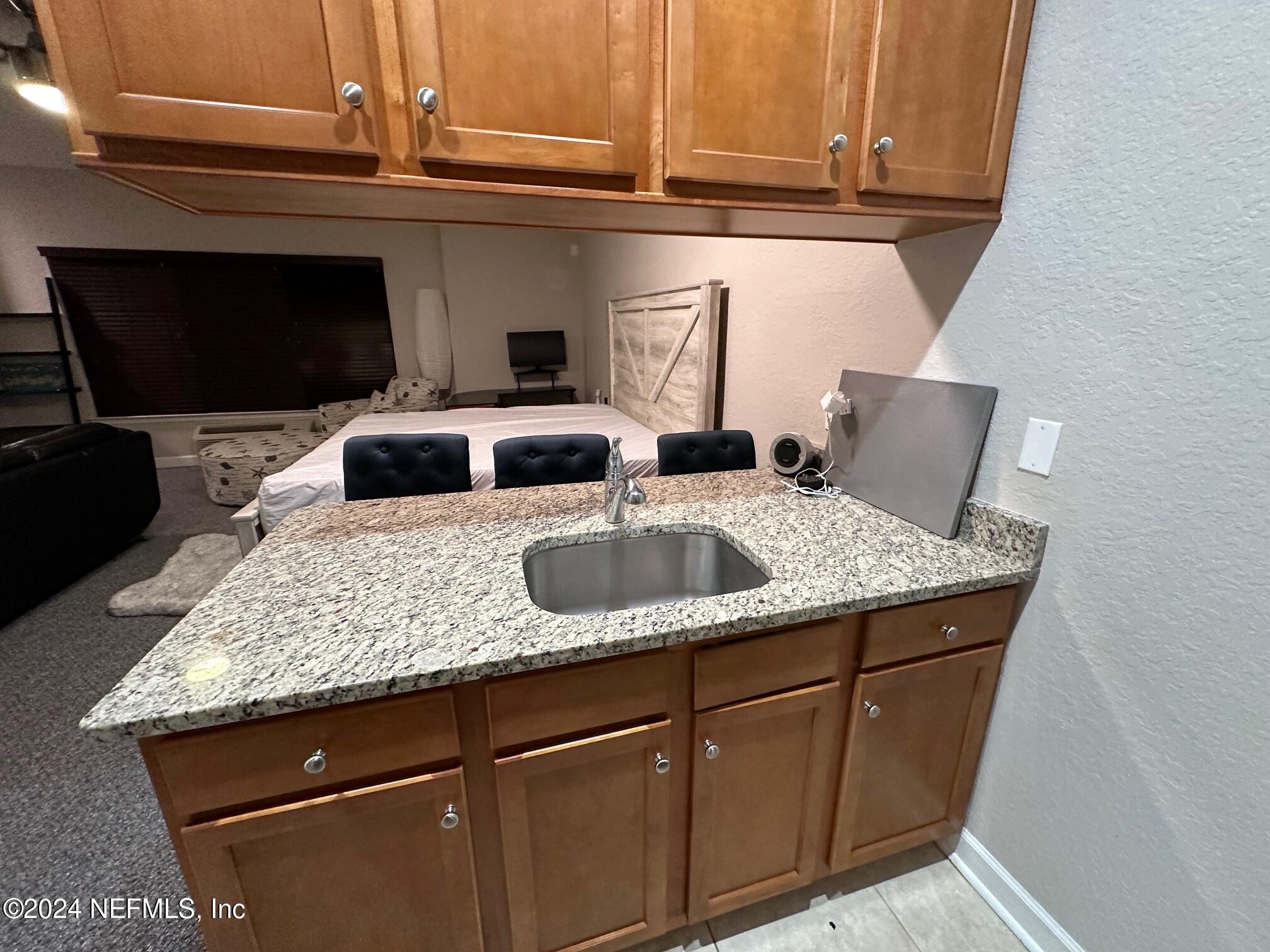 634 Market Street St. Augustine, FL 32095 - Photo 8 of 8 a kitchen with stainless steel appliances granite countertop a sink a microwave cabinets and a dining table