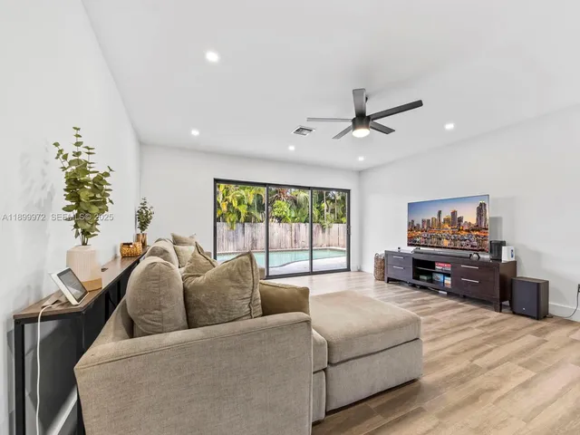 a living room with furniture and a flat screen tv with wooden floor