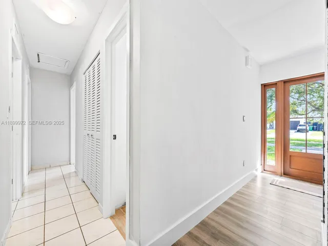 a view of a hallway with wooden floor and chandelier