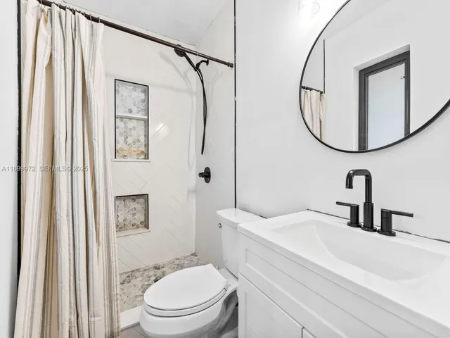 a bathroom with a sink a toilet and a mirror