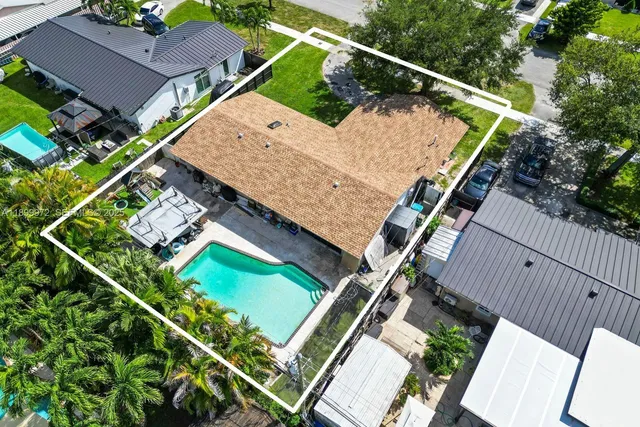 an aerial view of a house with a garden and swimming pool