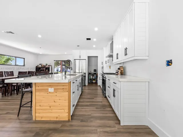 a large kitchen with stainless steel appliances granite countertop a stove and a sink