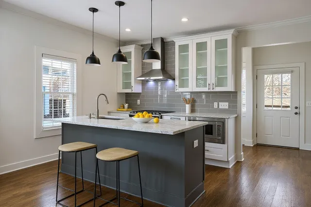 an empty room with wooden floor closet and windows