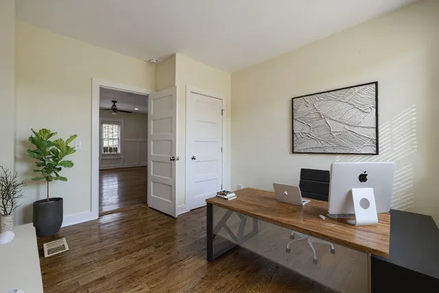an empty room with wooden floor and a ceiling fan