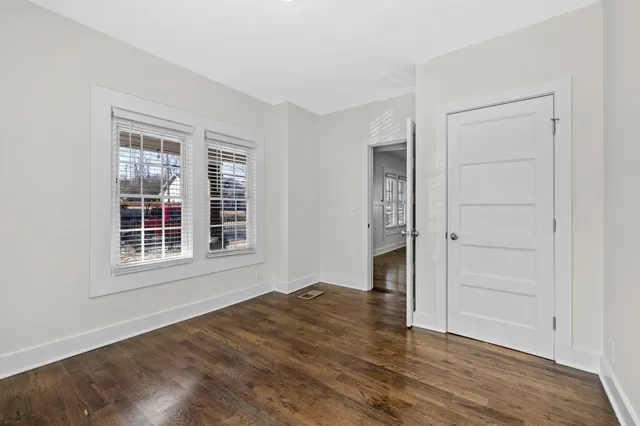 an empty room with wooden floor and ceiling fan