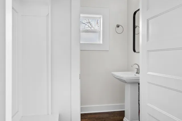 a kitchen with kitchen island a counter top space a sink a refrigerator and wooden floor