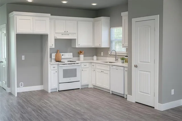 a kitchen with white cabinets stainless steel appliances and sink