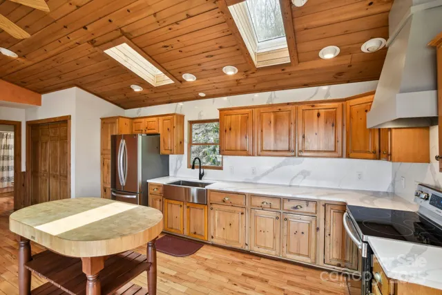 a kitchen with a table chairs sink and cabinets