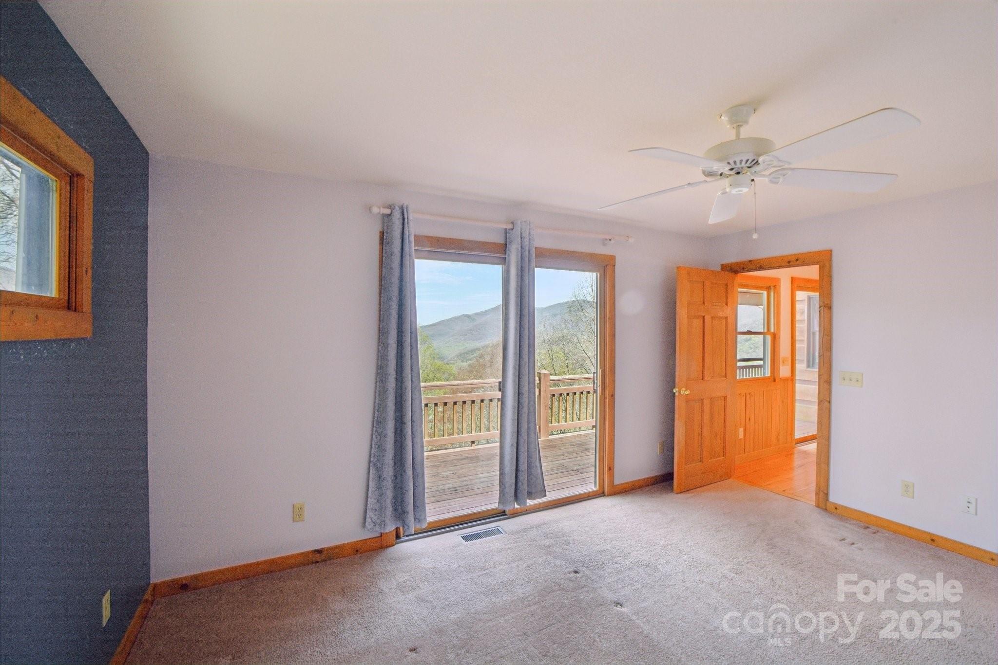 1426 Setzercove Road Maggie Valley, NC 28751 - Photo 25 of 48 an empty room with windows and fan