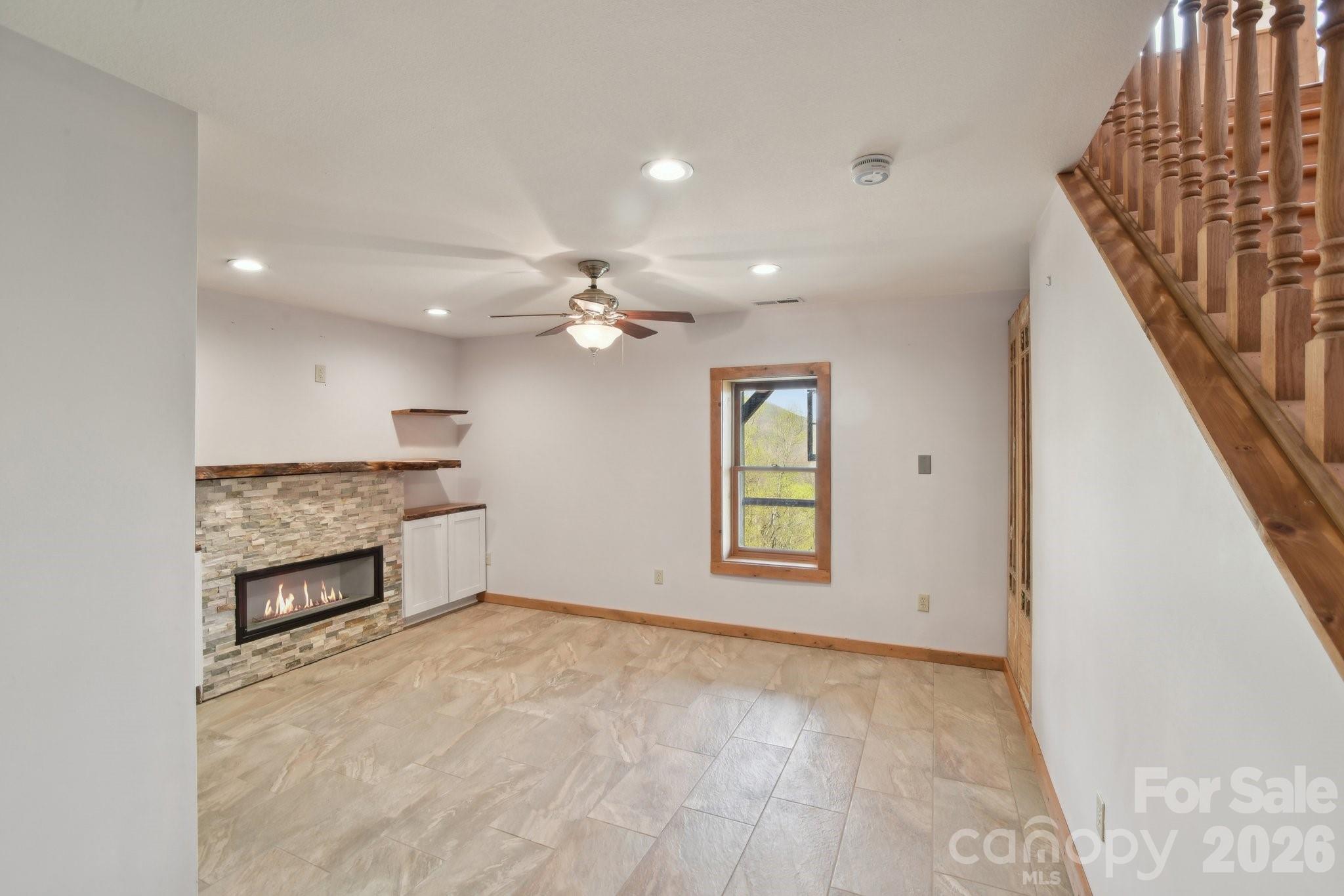 1426 Setzercove Road Maggie Valley, NC 28751 - Photo 28 of 48 an empty room with windows and fireplace