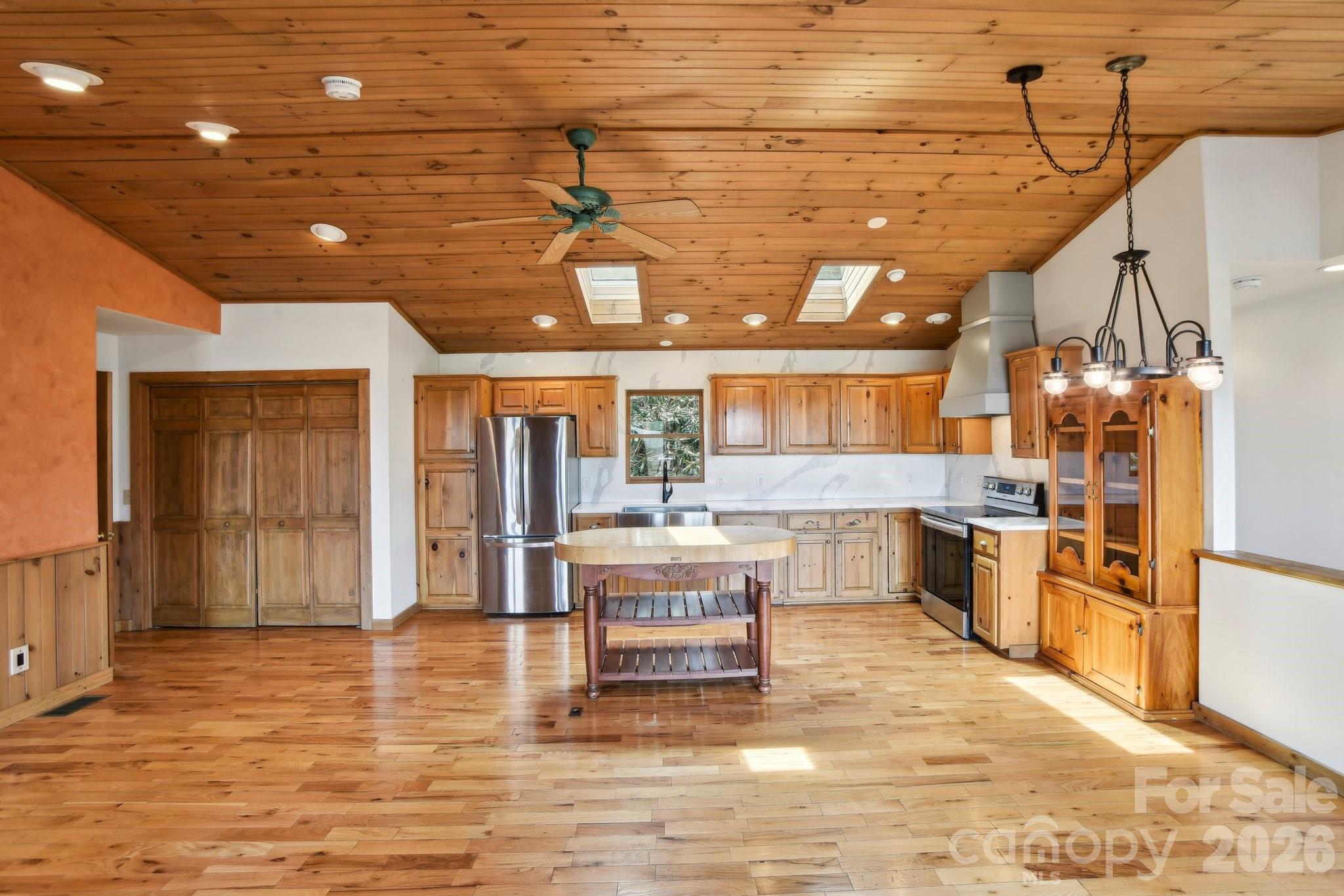 1426 Setzercove Road Maggie Valley, NC 28751 - Photo 10 of 48 a kitchen with a sink and wooden cabinets