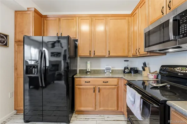 a kitchen with stainless steel appliances granite countertop a stove a refrigerator and a cabinets