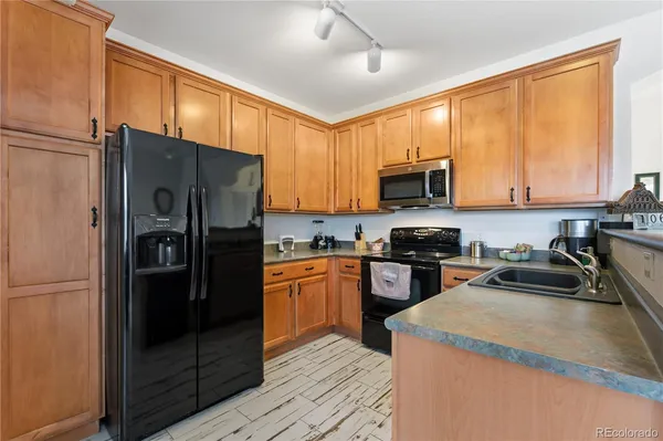 a kitchen with stainless steel appliances granite countertop a refrigerator stove top oven a sink and dishwasher