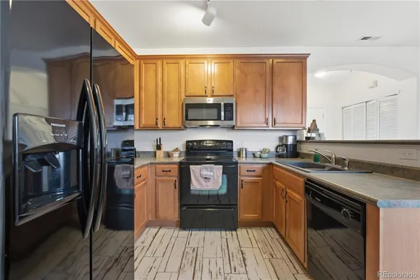 a kitchen with stainless steel appliances granite countertop a stove a sink and a microwave