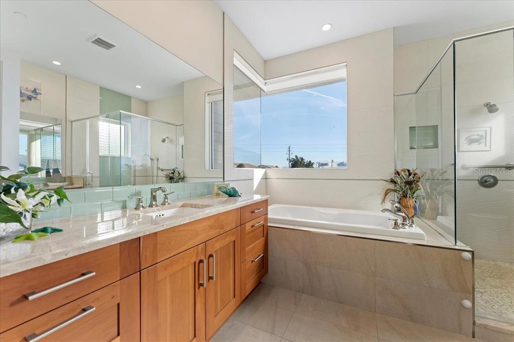 2708 North Beach Road, Unit 2 Englewood, FL 34223 - Photo 37 of 65 a bathroom with a granite countertop sink mirror and a bathtub