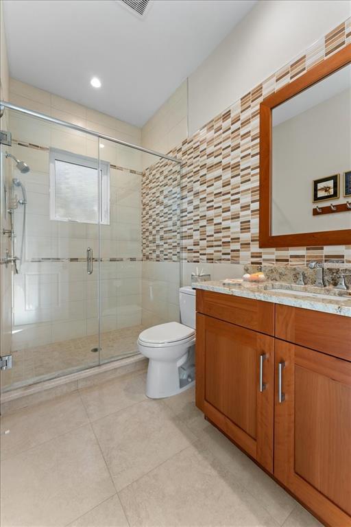 2708 North Beach Road, Unit 2 Englewood, FL 34223 - Photo 43 of 65 a bathroom with a granite countertop sink toilet and shower