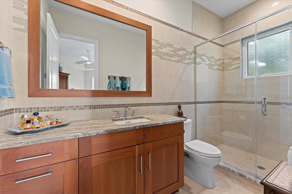 2708 North Beach Road, Unit 2 Englewood, FL 34223 - Photo 50 of 65 a bathroom with a granite countertop sink toilet and shower