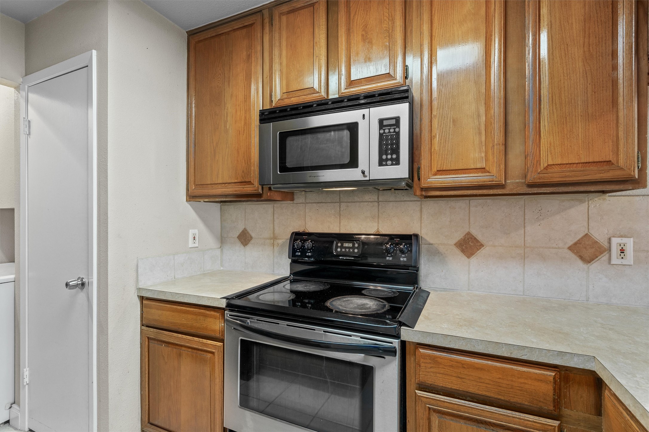806 West 24th Street, Unit 326 Austin, TX 78705 - Photo 11 of 33 a kitchen with granite countertop cabinets stainless steel appliances and wooden cabinets