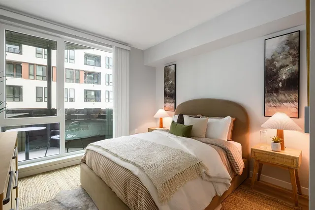 a bedroom with a balcony a bed and a lamp with window