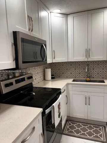 a kitchen with a sink stove and microwave