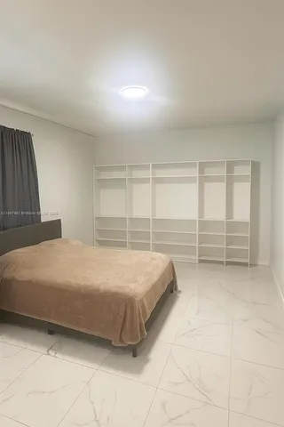 a spacious bedroom with a bed and cabinet