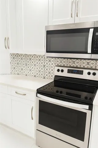 a stove top oven sitting inside of a kitchen