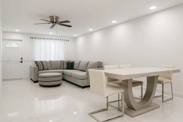 a living room with furniture and a view of kitchen