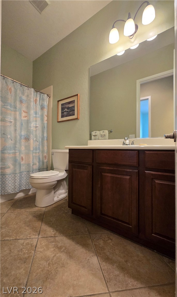 2567 Dirleton Place Henderson, NV 89044 - Photo 46 of 67 Guest Bathroom. A well-appointed bathroom features a dark wood vanity, broad mirror, and tiled flooring.