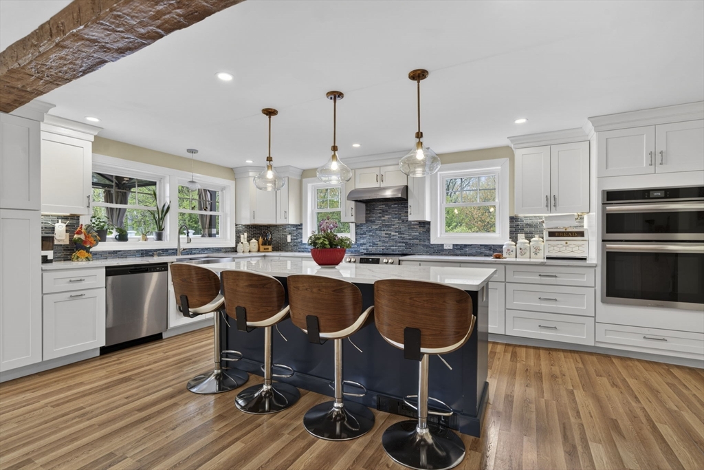 229 Parkerville Road Southborough, MA 01772 - Photo 33 of 38 a kitchen with kitchen island granite countertop a table chairs a sink dishwasher and cabinets with wooden floor