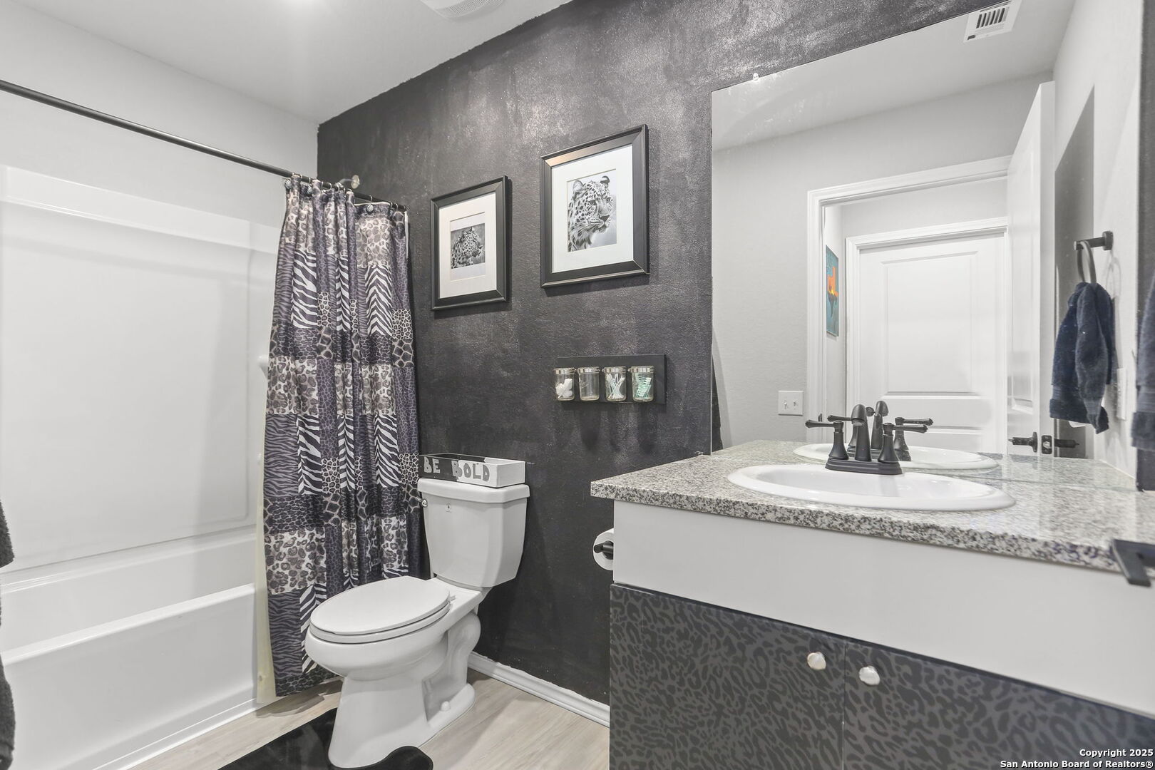 11910 Pewee San Antonio, TX 78221 - Photo 11 of 18 a bathroom with a granite countertop toilet sink and mirror