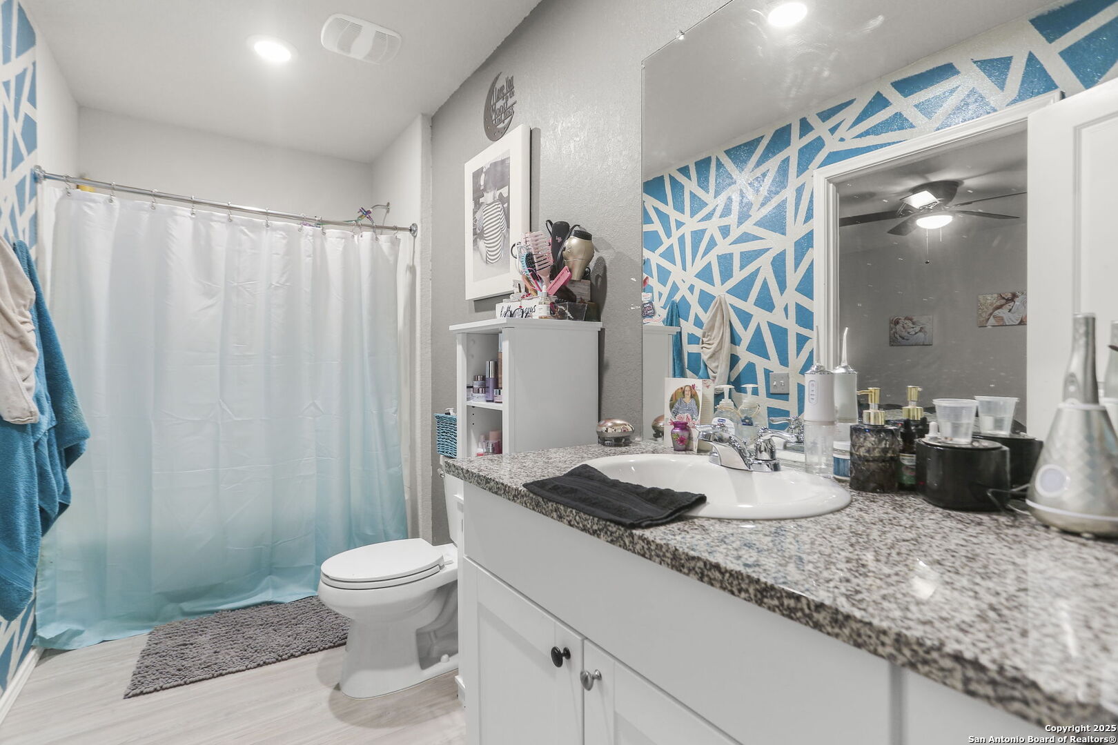 11910 Pewee San Antonio, TX 78221 - Photo 15 of 18 a bathroom with a granite countertop sink a toilet and shower curtain