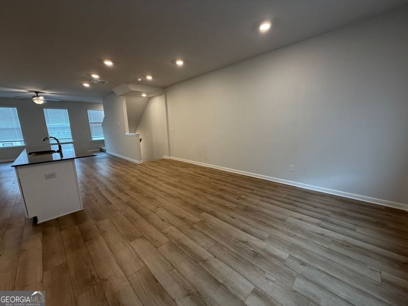 822 Werner Brook Way Southwest Atlanta, GA 30354 - Photo 16 of 55 an empty room with wooden floor and a kitchen view